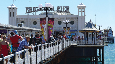 A sunny day at Brighton Pier with a view of the walkway to the pier