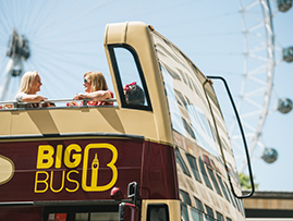 A zoomed in view of the upper deck of the Big Bus Tour with the London Eye as a background
