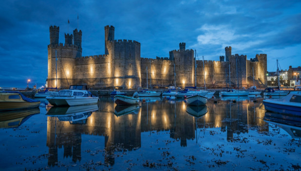 Night view of an illuminate Caernarfon Castle from the port