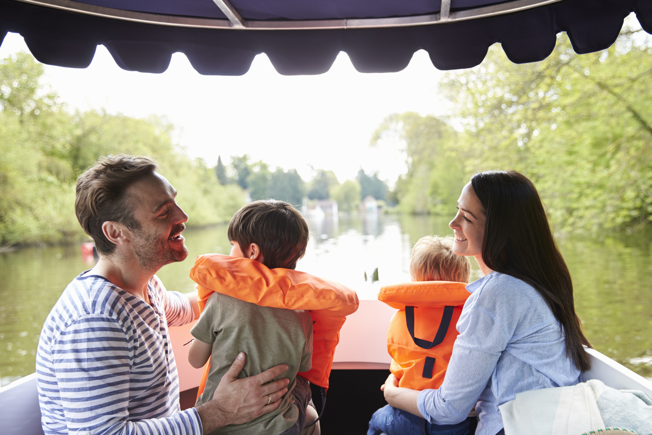 Family  of four enjoying a day out in a boat on the river together
