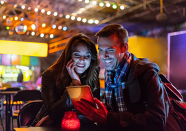 A couple choosing food on a menu at a resturant