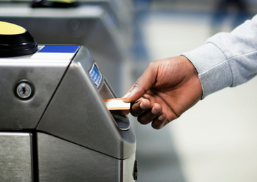 Man inserting a paper train ticket in the barrier