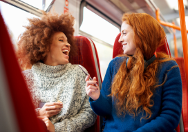Two friends talking and riding a train
