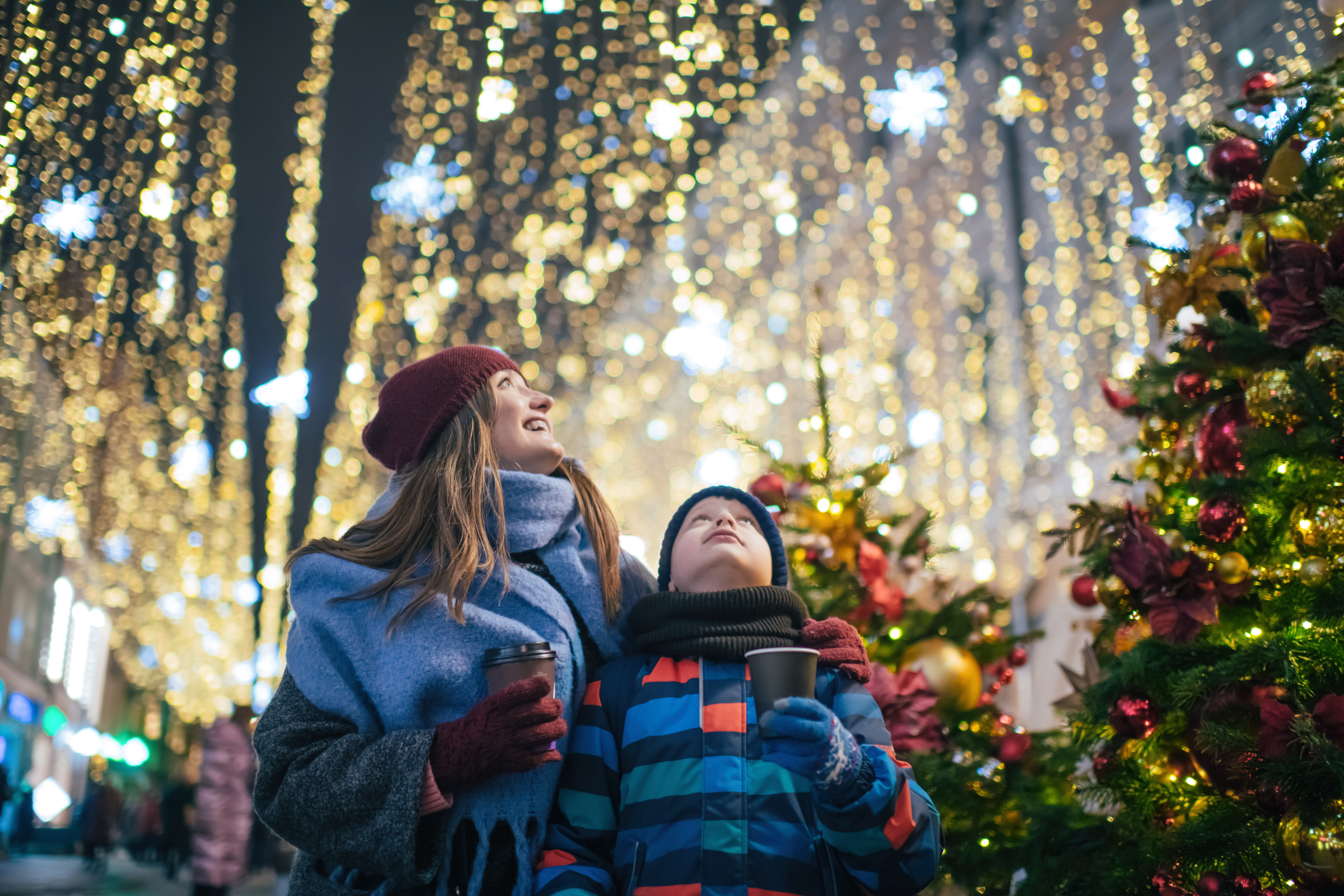 Little boy with his mother buying tea and sweets at a Christmas market